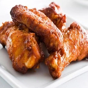 Saucy halal chicken wings tossed in bold sauce at Donair and Poutine House in Edmonton, AB