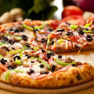 Fresh oven-baked halal pizza loaded with toppings at Donair and Poutine House in Edmonton, AB